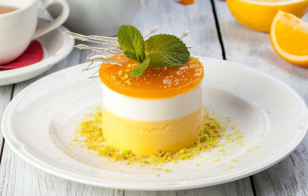 Вкусный десерт с мятой и фисташками на белой тарелке 