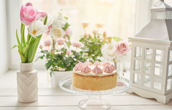 Вкусный пирог на столе с букетом тюльпанов 