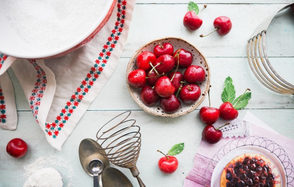 Мокрые ягоды черешни на столе с пирожным