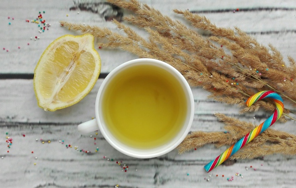 Чашка чая на столе с лимоном и колосьями