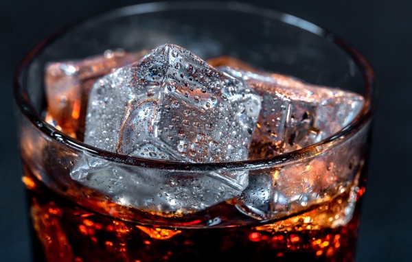 Coca cola drink in a glass with ice cubes