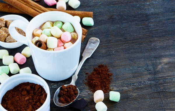 Кофе с маршмеллоу на столе с корицей и сахаром