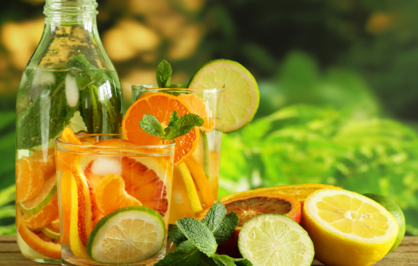 Холодный лимонад на столе с цитрусовыми