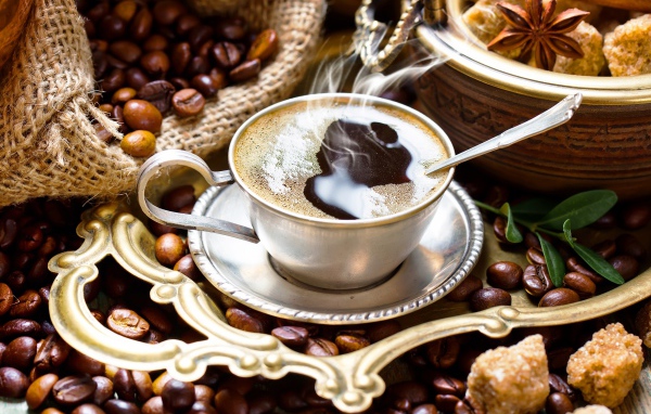 Чашка горячего вкусного кофе на столе с зернами