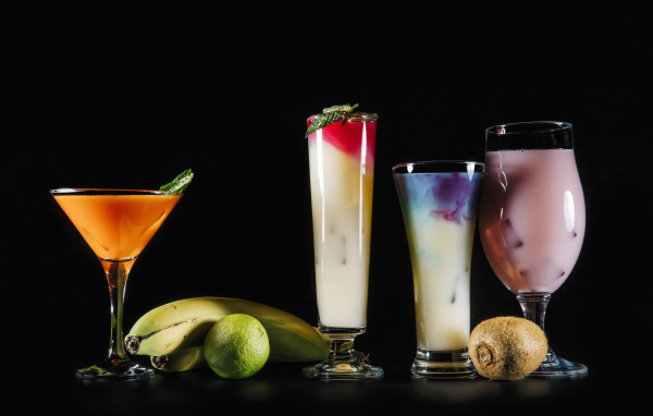 Вкусные тропические коктейли на черном фоне с фруктами