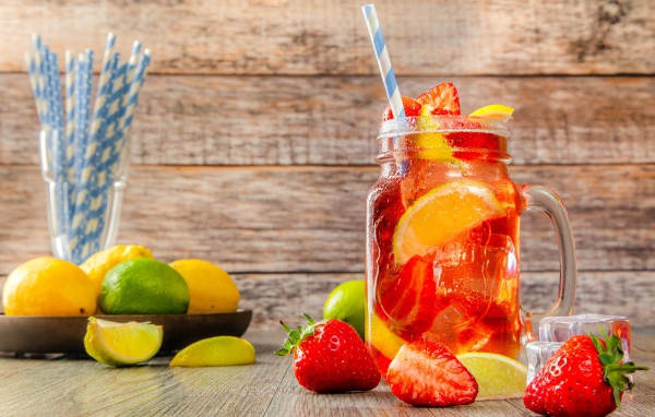 Напиток с клубникой и лимоном в банке на столе 