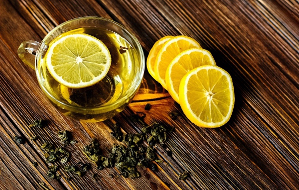 Зеленый чай в стеклянной чашке с лимоном