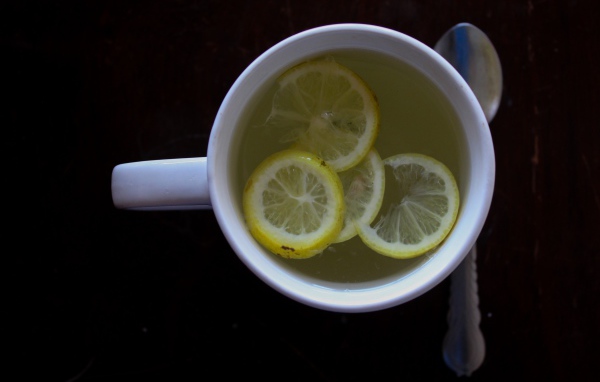 Зеленый чай с лимоном на черном фоне