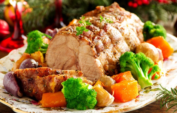 Кусок запеченного мяса на тарелке с овощами