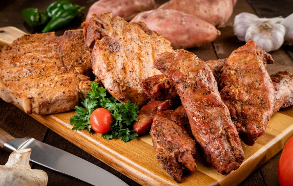 Аппетитное запеченное мясо на столе с чесноком и картофелем