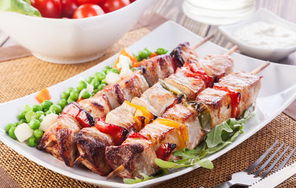 Аппетитный шашлык на тарелке с горохом