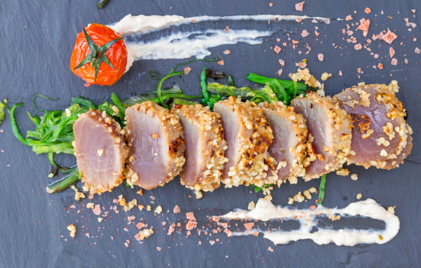 Вяленое мясо на столе с зеленью и помидором 