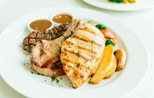 Запеченное мясо гриль на тарелке с овощами