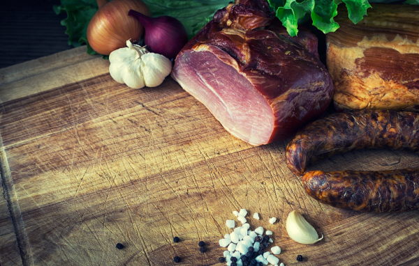 Мясные продукты на столе со специями, луком и чесноком 
