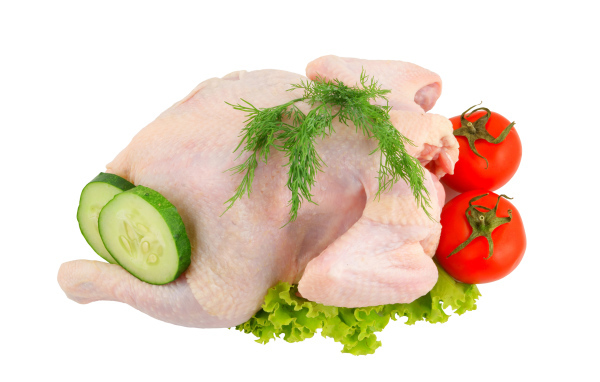 Сырая курица с помидорами, огурцами и листьями салата