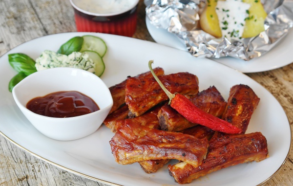 Ребрышки на тарелке с соусом и острым перцем