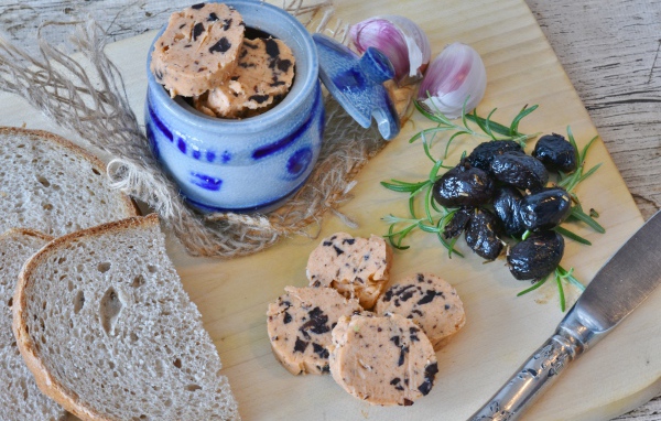 Колбаса с маслинами на столе с хлебом и чесноком