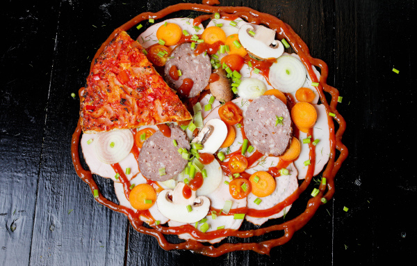 Пицца с овощами и колбасой на столе с кетчупом 
