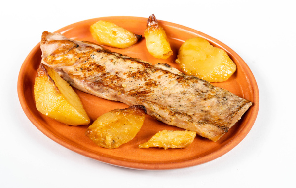 Кусок запеченной рыбы на тарелке с картофелем 