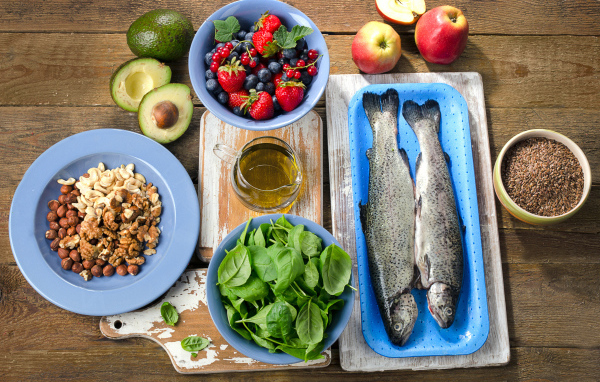 Fresh fish on a table with nuts, basil and berries