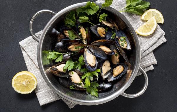 Fresh mussels in a saucepan with parsley