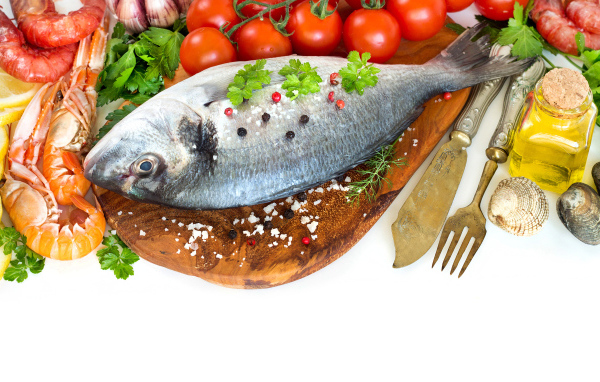 Сырая рыба на столе с маслом и помидорами 