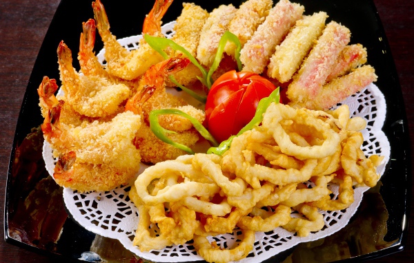 Морепродукты в кляре на тарелке с помидором