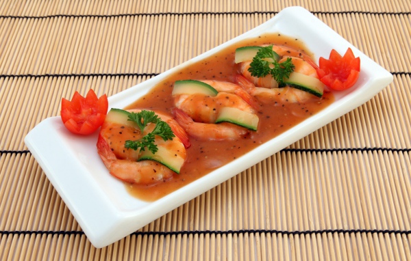 Креветки с огурцом в соусе на столе 