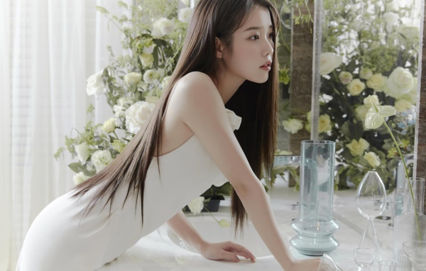 Красивая девушка азиатка в белом платье стоит у зеркала