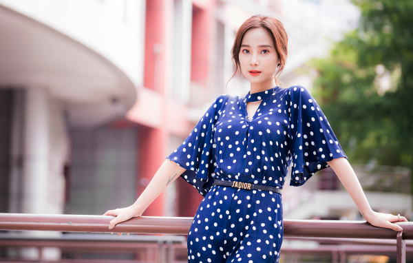 Девушка азиатка в синем платье в белый горошек