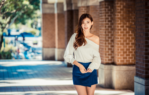 Девушка азиатка в короткой юбке у стены