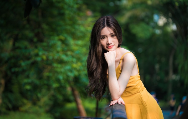 Девушка азиатка с большими карими глазами в желтом платье 