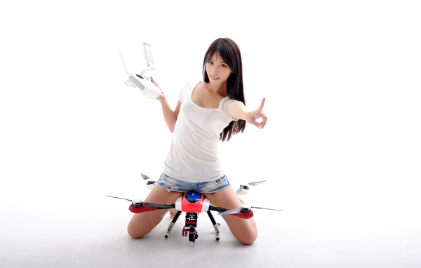 Девушка азиатка с квадрокоптером на белом фоне