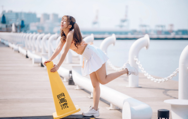 Азиатка с короткой белой юбке у воды 