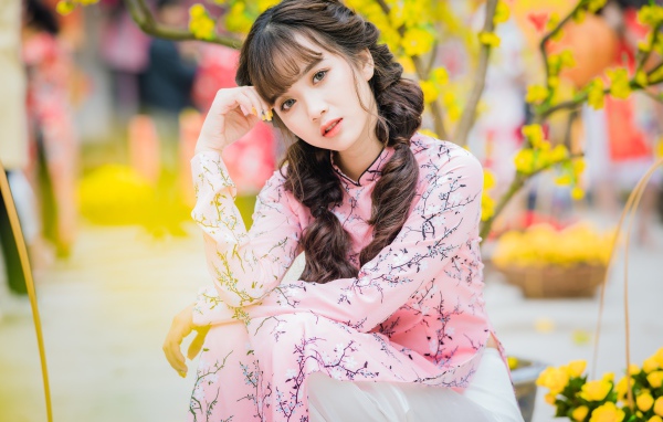 Красивая девушка азиатка в красивом розовом наряде в парке