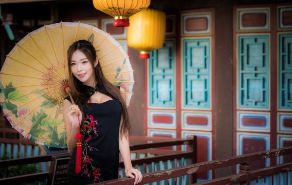 Красивая девушка азиатка в черном платье с зонтом
