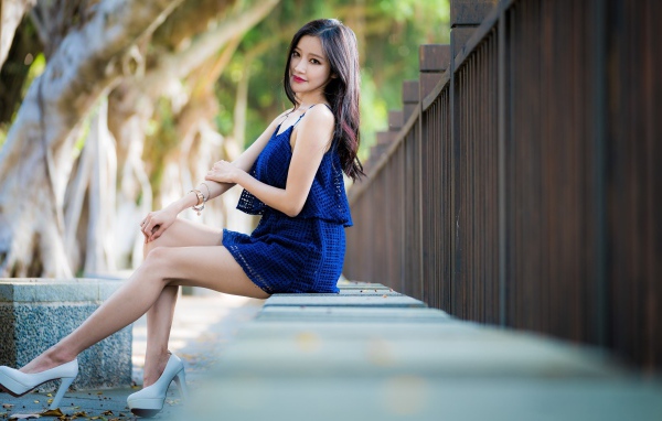 Красивая девушка азиатка в синем платье в парке