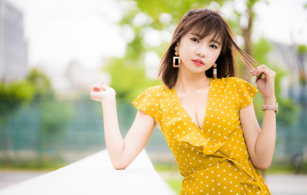 Красивая азиатка в желтом платье в белый горох 