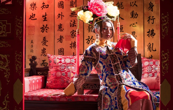 Красивая девушка азиатка в национальном костюме на диване