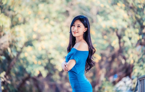 Красивая девушка азиатка с милой улыбкой в голубом платье 