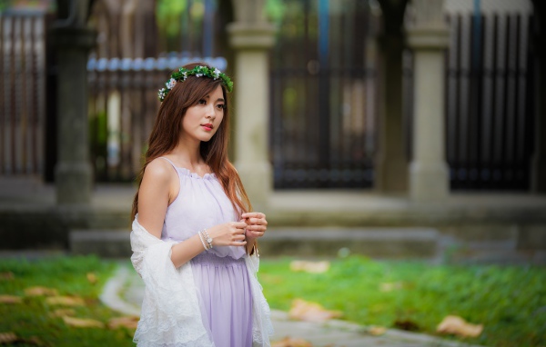 Красивая азиатка в сиреневом платье с венком на голове