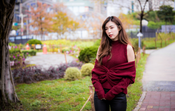 Красивая девушка азиатка в красном наряде в парке