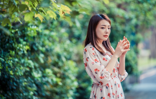 Красивая девушка азиатка в платье в парке