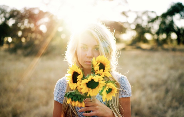 Красивая блондинка с букетом подсолнухов в руках