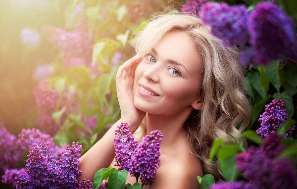 Красивая голубоглазая девушка блондинка в цветах сирени