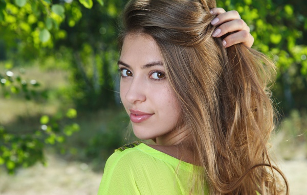 Красивая кареглазая шатенка с рукой в волосах 