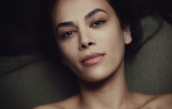 Красивая кареглазая девушка лежит на диване 