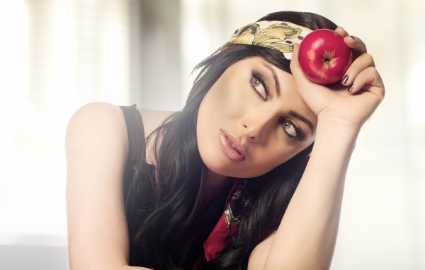 Красивая брюнетка с яблоком в руке 