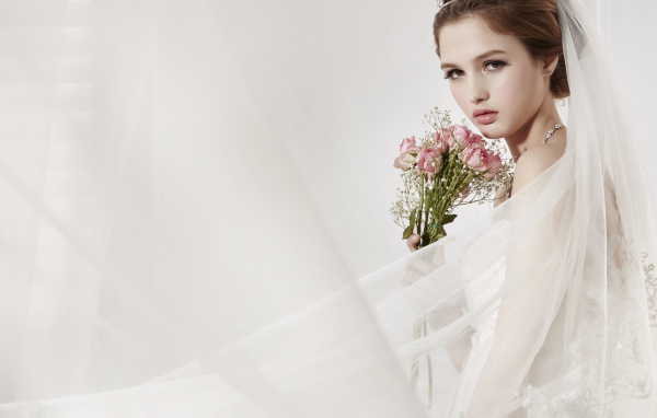 Красивая девушка невеста в свадебном платье с букетом роз 