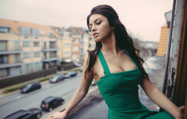 Красивая девушка в зеленом платье на балконе